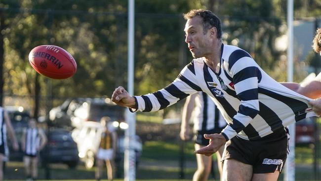 Narre Warren’s Brad Scalzo handballs. Picture: Valeriu Campan