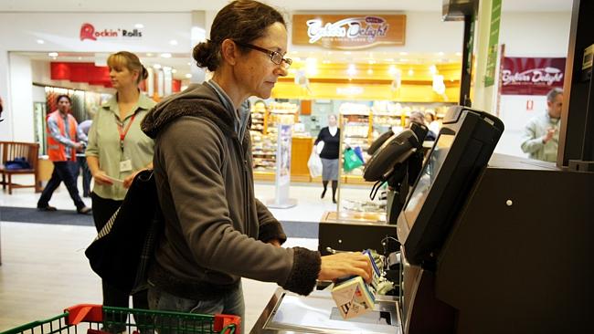 How do I work this bloody thing again? A shopper grapples with a self-service check-out.