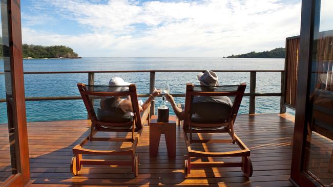 Couple relaxing on sun lounges in an over water bungalow, Fijicredit: iStockescape13 june 2021doc holiday