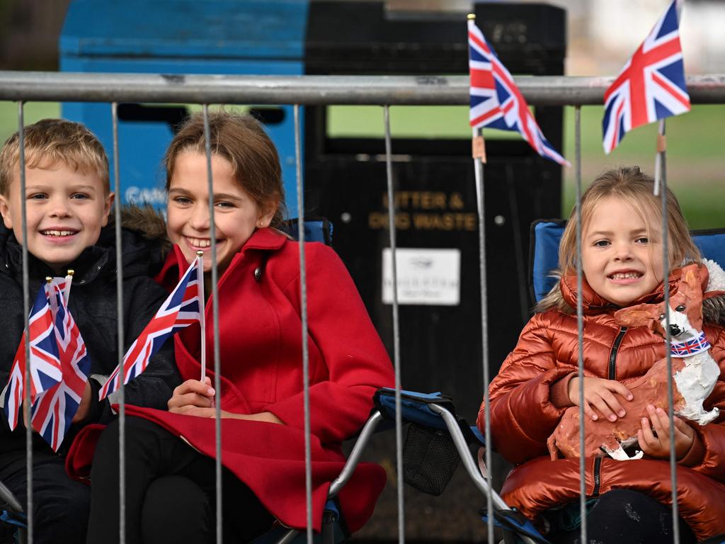 Children sit behind barriers in Ballater on September 11, 2022 as they wait for Queen Elizabeth II's coffin to travel through the Scottish village. Picture: AFP.