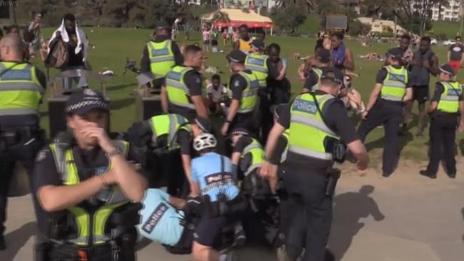 Stills from Neil Erikson’s video show police restraining a youth at St Kilda Beach.