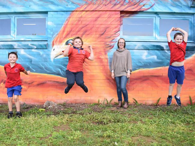 Rappville Public School principal Kat Collis with students in front of their phoenix mural.