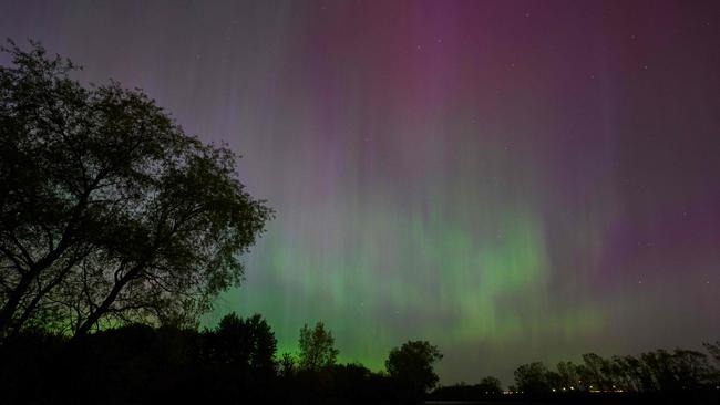 Northern lights or aurora borealis illuminate the night sky near London, Ontario, during a geomagnetic storm on May 10, 2024. The most powerful solar storm in more than two decades struck Earth on May 10, 2024, triggering spectacular celestial light shows in skies from Tasmania to Britain – and threatening possible disruptions to satellites and power grids as it persists into the weekend. Auroras are often observed in Canada's northern regions, but rarely in southern Ontario. (Photo by Geoff Robins / AFP)