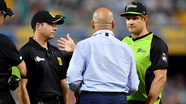 Sydney Thunder captain Shane Watson talks with BBL match officials after play was suspended when a light tower lost power at the Gabba on Thursday night. Picture: AAP