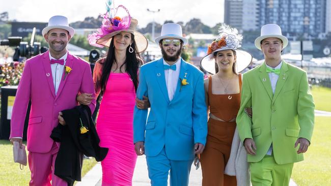 Brightly coloured horse fanatics strut alongside the race track. Photo by Jay Town/Racing Photos via Getty Images)