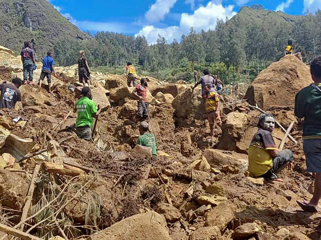 This handout photo taken and received on May 29, 2024 courtesy of Nickson Pakea, president of Porgera Chamber of Commerce and Industry, shows locals digging at the site of a landslide at Yambali village in the region of Maip Mulitaka, in Papua New Guinea's Enga Province. (Photo by NICKSON PAKEA)