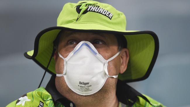 A Sydney Thunder fans dons a face mask. Picture: AAP