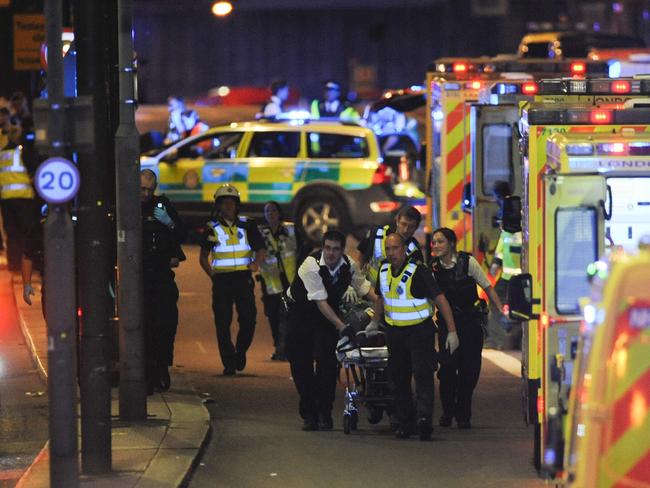 Police officers and members of the emergency services attend to a person injured in an apparent terror attack on London Bridge. Picture: AFP