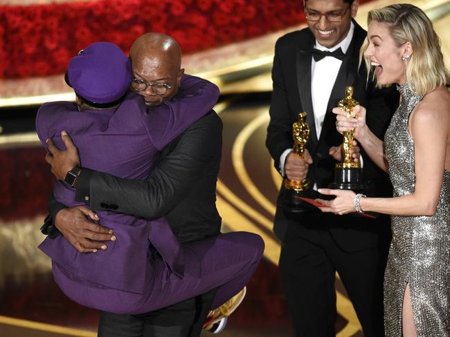 Samuel L. Jackson, center left, embraces Spike Lee, winner of the award for best adapted screenplay for "BlacKkKlansman" as Brie Larson, right, looks on, at the Oscars on Sunday, Feb. 24, 2019, at the Dolby Theatre in Los Angeles. (Photo by Chris Pizzello/Invision/AP)