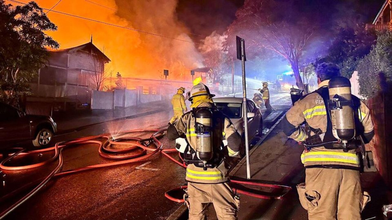 Firefighters at the scene of a major fire at Woolloongabba, where a unit might be in reach of essential services but houses are expensive, and few and far between. Picture: QAS