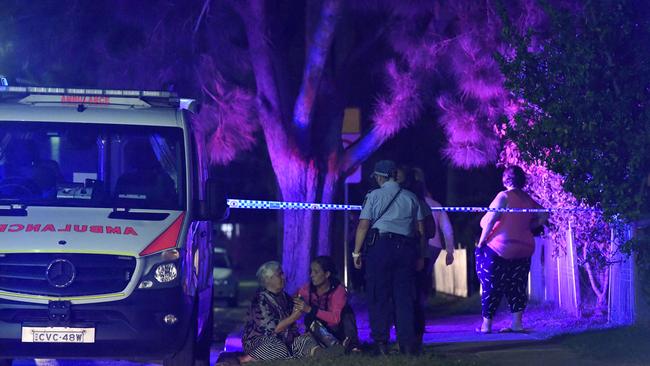 Distraught family and friends gathered outside the Dharruk home after the attack. Picture: Gordon McComiskie