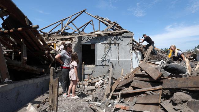 Residents stand in the remains of their homes as municipal workers clear debris in the aftermath of a Russian attack on Kramatorsk on June 14, 2023. Picture: AFP