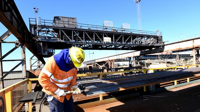 A steel worker grinds a piece of railway track at Arrium’s steelworks in Whyalla.