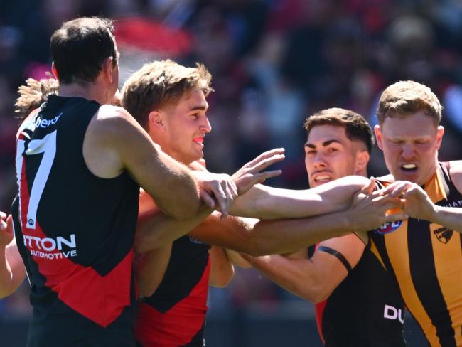 MELBOURNE, AUSTRALIA – MARCH 16: Bombers players remonstrate with James Sicily of the Hawks after he gave away a free kick to Andrew McGrath of the Bombers during the round one AFL match between Essendon Bombers and Hawthorn Hawks at Melbourne Cricket Ground, on March 16, 2024, in Melbourne, Australia. (Photo by Quinn Rooney/Getty Images)