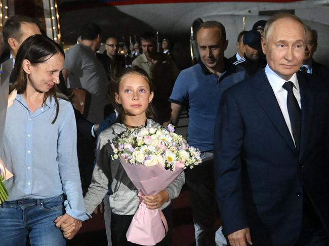 In this pool photograph distributed by Russian state agency Sputnik, Russia's President Vladimir Putin welcomes Russian citizens released in a major prisoner swap with the West, at Moscow's Vnukovo airport on August 1, 2024. (Photo by Mikhail VOSKRESENSKIY / POOL / AFP)