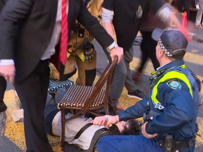 Bystanders subdue the accused slasher with chairs. Picture: Seven News