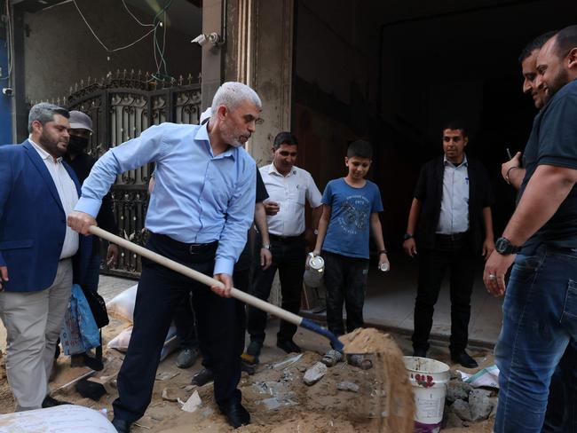 (FILES) In this file picture dated May 26, 2021, the leader of the Palestinian Hamas movement's political wing, Yahya Sinwar, tours the Al-Rimal neighbourhood in Gaza City, to assess the damage caused during the recent bombing by Israeli forces. Israel conducted raids on Gaza on October 18, 2024, pressing its year-long war to crush Hamas after dealing it a massive blow with the killing of its leader, Yahya Sinwar, the previous day. Hailing the killing of Sinwar, Israeli Prime Minister Benjamin Netanyahu said the war sparked by Hamas's October 7, 2023 attack was not over, but added that it was "the beginning of the end". (Photo by MOHAMMED ABED / AFP)