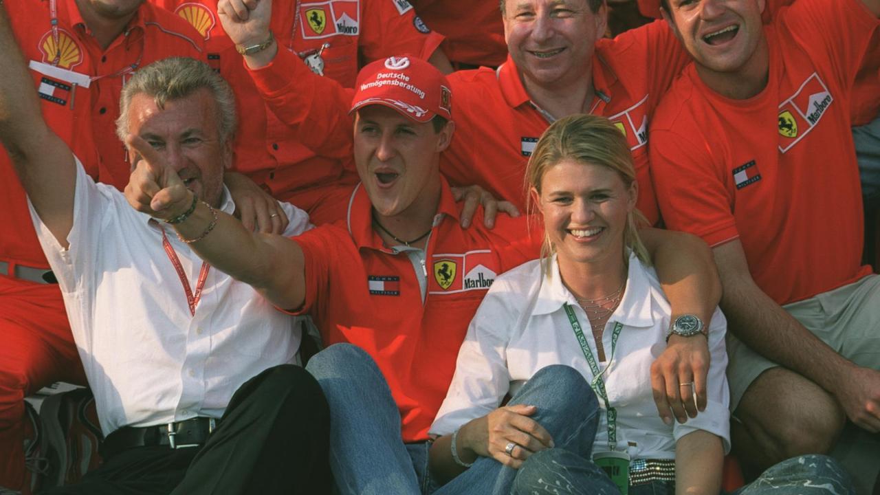Michael Schumacher celebrates with manager Willi Weber and wife Corrina. Photo by Steve Mitchell/EMPICS via Getty Images)