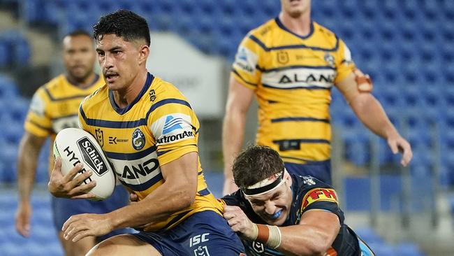 Dylan Brown of the Eels gets through a tackle by Jarrod Wallace of the Titans during the Round 2 NRL match between the Gold Coast Titans and the Parramatta Eels at CBus Super Stadium on the Gold Coast, Sunday, March 22, 2020. (AAP Image/Dave Hunt)