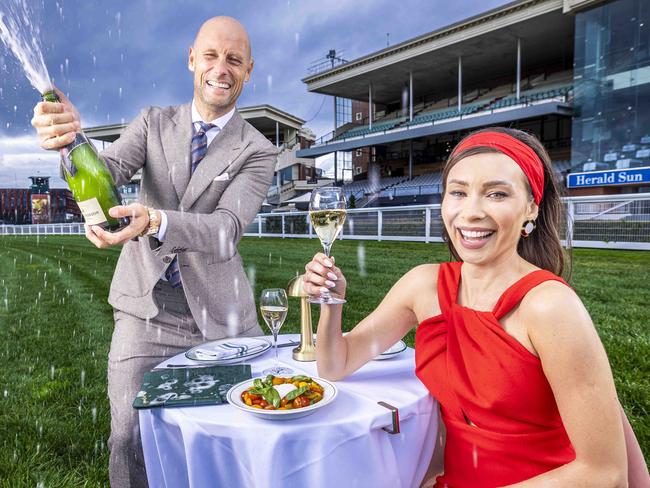 Bar Bambi mock restaurant to be set up on the home straight at Caulfield Racecourse Tables, chairs, table clothes, table lamps etc to be on display with signature food and drink from Bar Bambi Rozalia Russian from Bar Bambi in a beautiful dress, sitting on a table, reading a menu Nick Russian from Bar Bambi possibly pouring her a glass of champagne. Picture by Wayne Taylor 16th August 2024