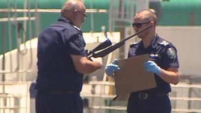 Police officers hold a rifle retrieved from the car. Pic: Seven News