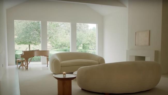 Another sitting space in the $23 million home features two curved couches and a grand piano set against floor-to-ceiling windows.