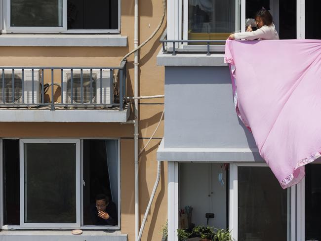 People look out of their windows at a residential community in Shanghai, entering its third week of a strict lockdown in an attempt to curb the Covid-19 outbreak. Picture: Getty Images