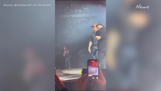 Latrell Mitchell shotguns a beer with Luke Combs onstage