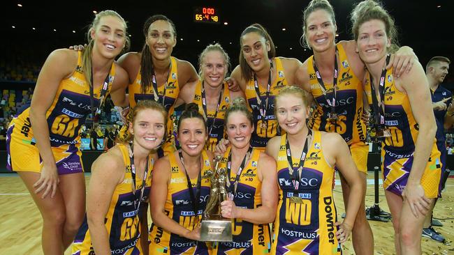 The Lightning pose for a team photo with the Suncorp Super Netball trophy.