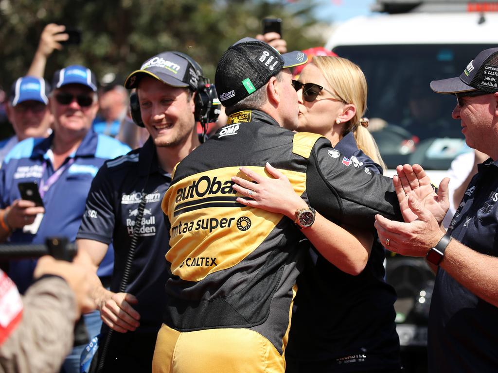 Craig Lowndes and his wife share a kiss.