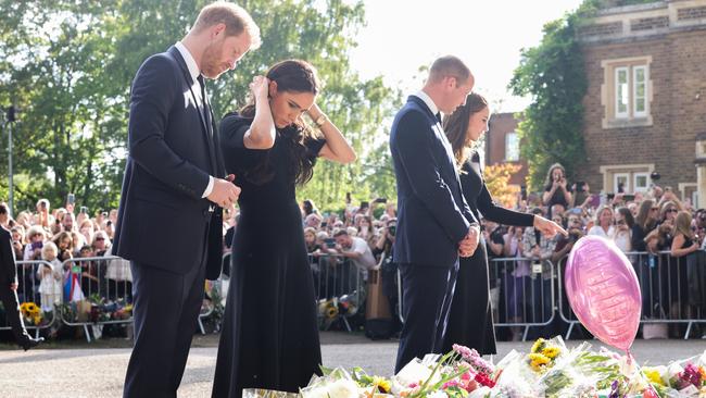 Prince Harry with the Duchess of Sussex, Meghan, and Prince William with Princess Kate look at floral tributes laid by members of the public for the Queen. Picture: Getty Images