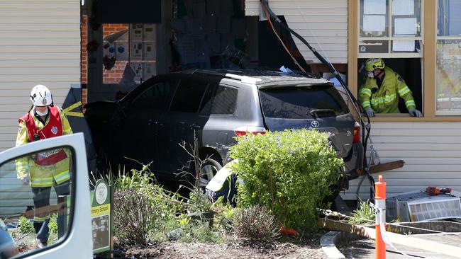 NSW Fire & Rescue officers work to remove the car from a classroom. Picture: Jonathan Ng