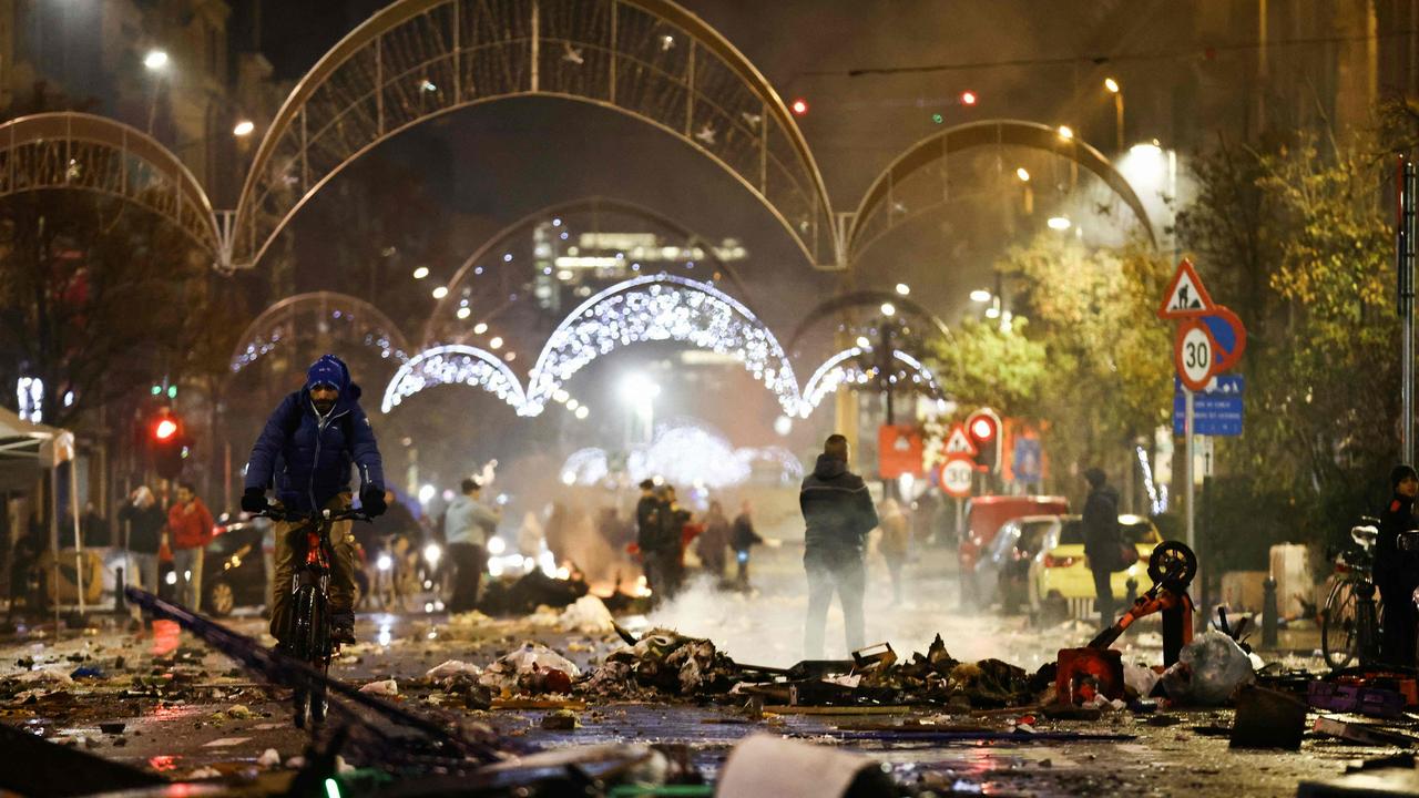 A cyclist rides among debris after the riots.