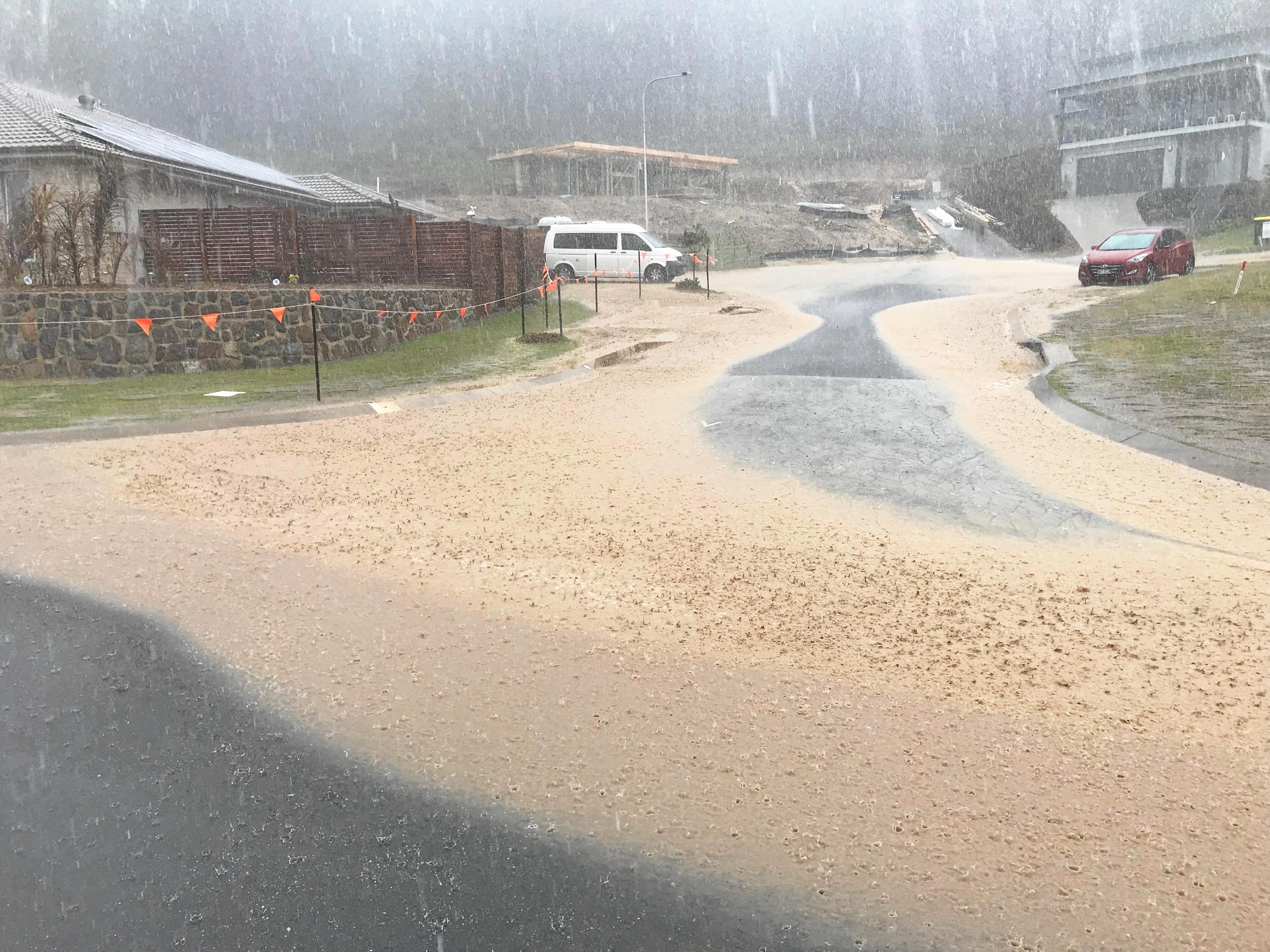 DELUGE: The downpours in mid-November sent muddy water sprawling across this street in Parklakes 2. Picture: Contributed