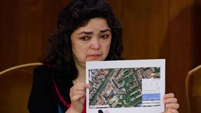 Witness Uighur teacher Qelbinur Sidik holds up a photograph of the hospital where she says she underwent a forced sterilisation procedure. Picture: Tolga Akmen / AFP