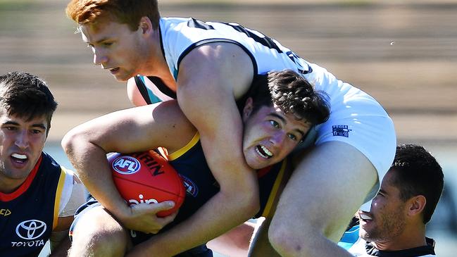 Ned McHenry is tackled by Port Adelaide’s Willem Drew in a pre-season game at Thebarton Oval. Picture: Mark Brake (AAP)