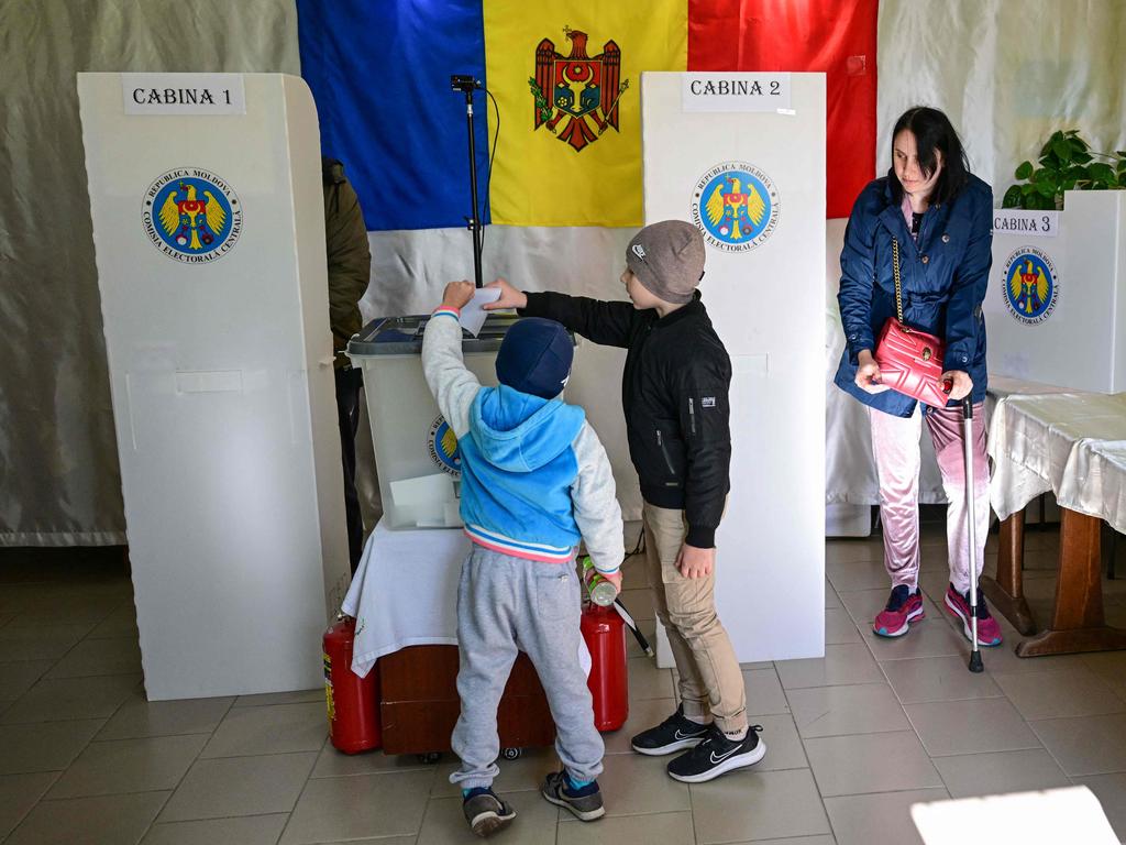 Children cast a ballot of a relative during Moldova's second round presidential election. Picture: AFP