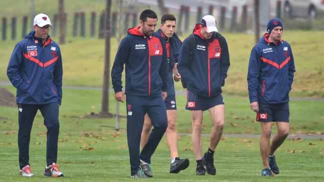 Melbourne players and staff return from training this morning. Picture: Tony Gough