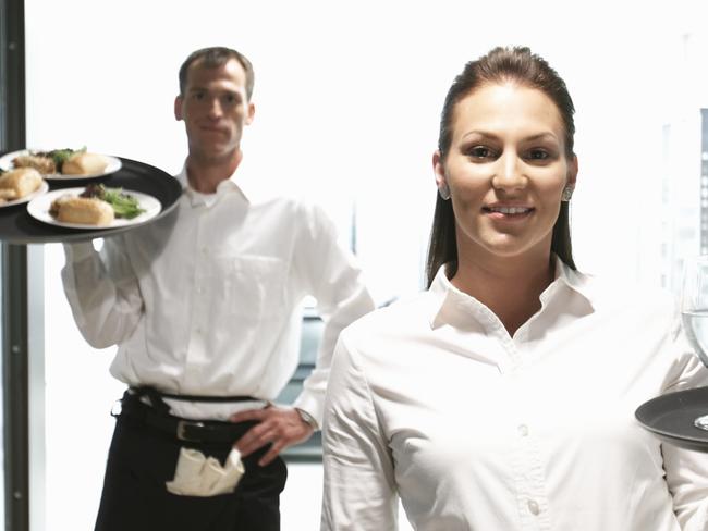 Waiter and waitress holding food and drink on trays, portrait