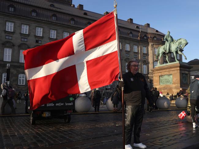 COPENHAGEN, DENMARK - JANUARY 14: A man holds a flag of Denmark in Christiansborg Palace square on January 14, 2024 in Copenhagen, Denmark. On January 14th, Her Majesty The Queen steps down as Queen of Denmark and entrusts the throne to His Royal Highness The Crown Prince. (Photo by Sean Gallup/Getty Images)