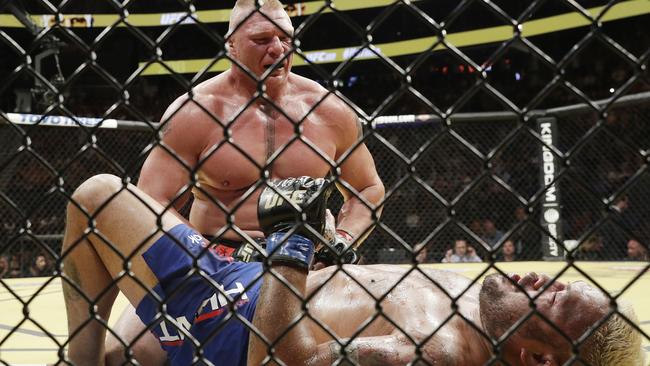 Brock Lesnar kneels over Mark Hunt.