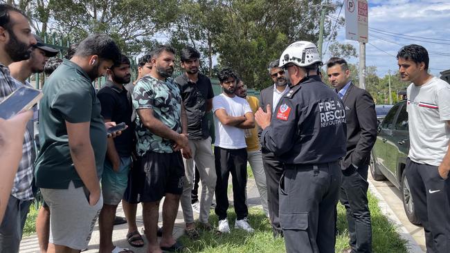 Fire and Rescue NSW Superintendent Adam Dewberry talks to friends of Haider Ali after the fatality.