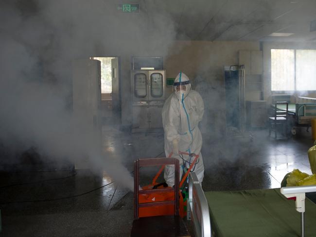 A worker wears a protective suit as he disinfects a room in the Wuhan No.7 hospital in Wuhan, in China's central Hubei province.