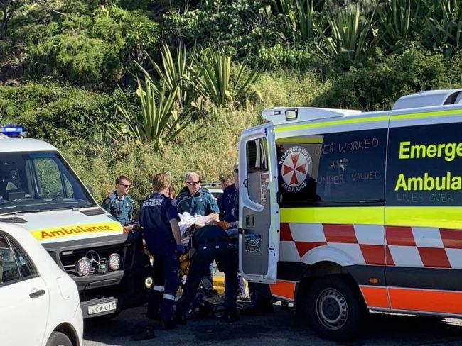 Paramedics load the woman in her 20s into an ambulance.