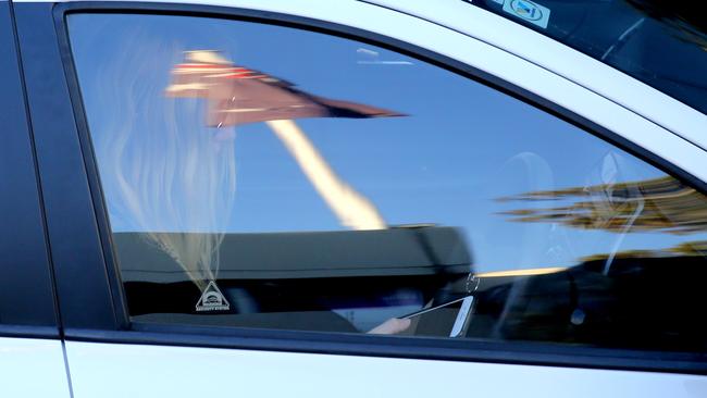 A woman checks her mobile while driving on Manly Rd. Picture: John Grainger