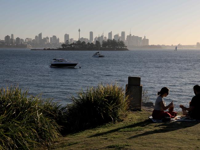 A couple have a picnic with Sydney harbour in the background, Milk Beach in Vaucluse, Sydney. 24th August, 2019. Picture by Damian Shaw