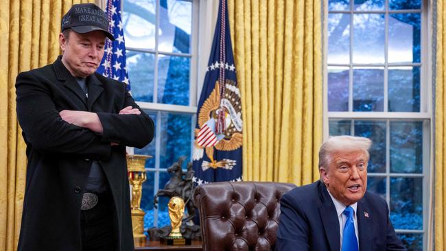 Elon Musk listens as US President Donald Trump speaks in the Oval Office of the White House in Washington, DC, on February 11, 2025. Tech billionaire Elon Musk, who has been tapped by President Donald Trump to lead federal cost-cutting efforts, said the United States would go "bankrupt" without budget cuts. Musk leads the efforts under the newly created Department of Government Efficiency (DOGE), and was speaking at the White House with Trump, who has in recent weeks unleashed a flurry of orders aimed at slashing federal spending. (Photo by Jim WATSON / AFP)