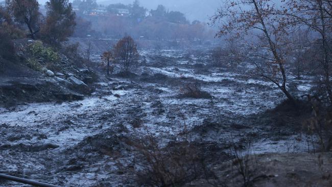 Caustic black water from the Eaton Fire rushes by in the Eaton Wash near Altadena, California, as an atmospheric river bring heavy rains on February 13, 2025. Residents of southern Californians are evacuating their homes because of the heavy rain and debris flows that threaten mudslides in areas recovering from wildfires. (Photo by David Swanson / AFP)