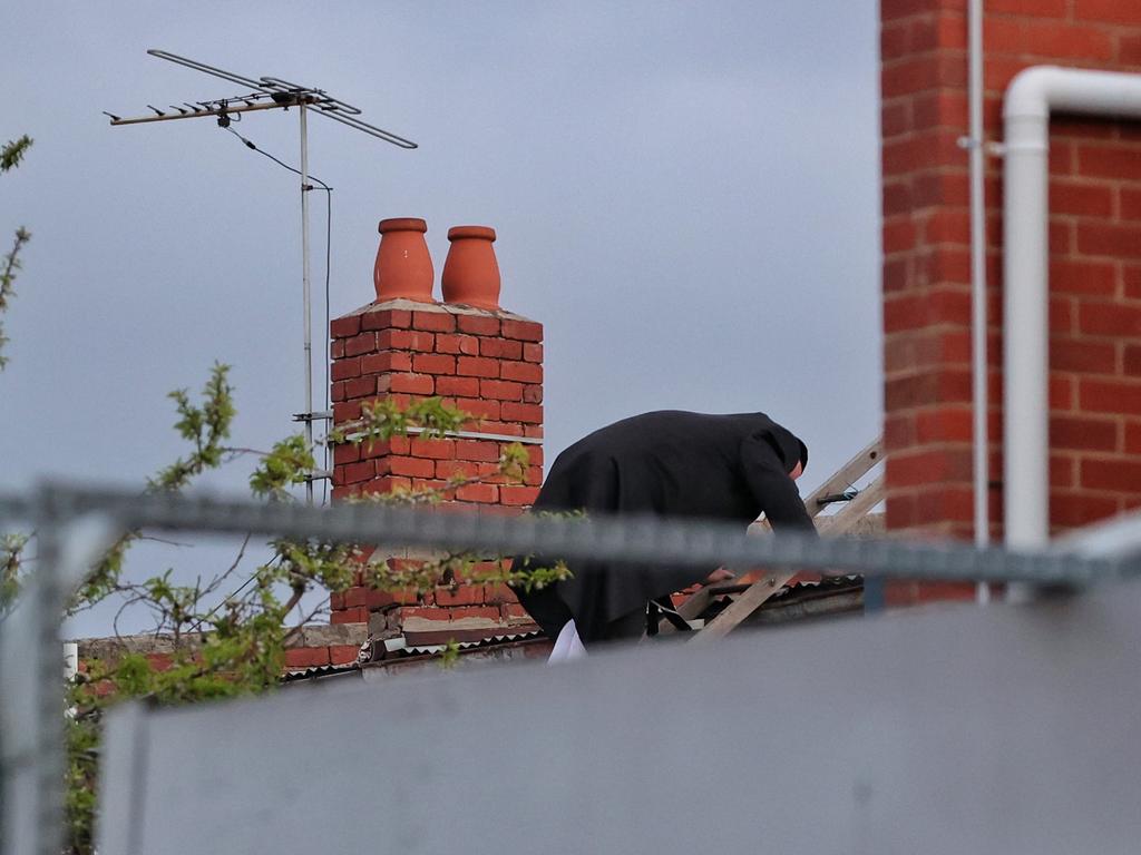 A man is seen on the roof of a building amid an illegal gathering at the Adass Israel Synagogue in Ripponlea. Picture: Mark Stewart