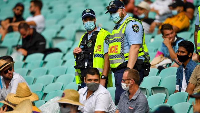 Police officers monitor spectators at the SCG. The decision to go ahead with the Sydney Test, even with spacing, is ‘inconsistent messaging’. Picture: AFP